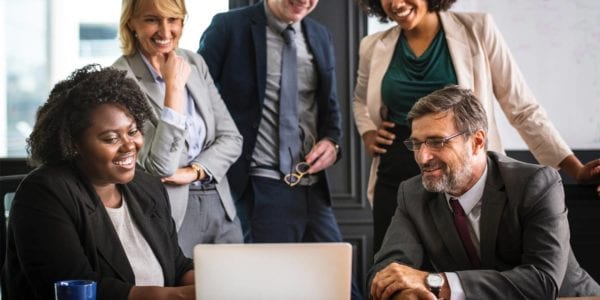 group of individuals working around laptop
