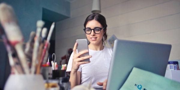 woman working on phone and laptop