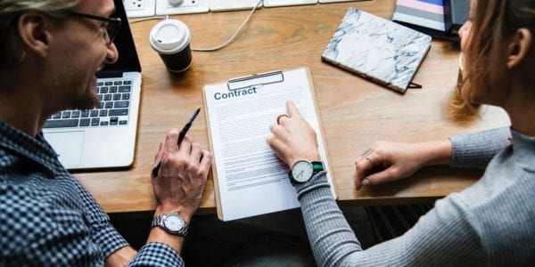 two individuals reviewing a contract
