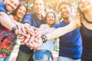 group of friends holding hands in the sun